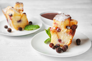 Delicious bread pudding with berries on wooden table