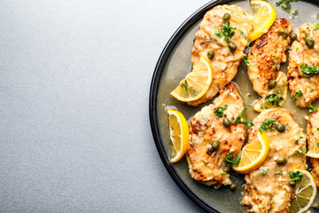 Plate with tasty Italian chicken piccata on table
