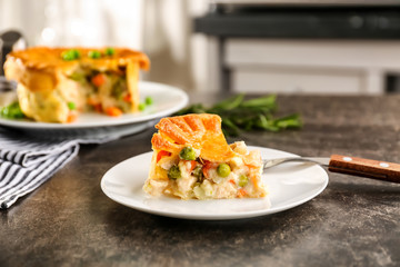 Plate with piece of delicious chicken pot pie on kitchen table