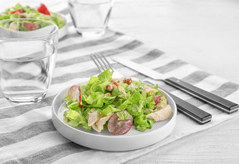 Plate with chicken salad and grapes on table