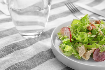 Plate with chicken salad and grapes on table