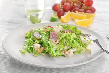 Plate with chicken salad and grapes on table