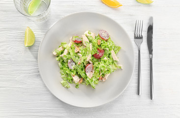 Plate with chicken salad and grapes on table