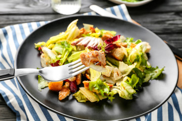 Plate with chicken salad on table