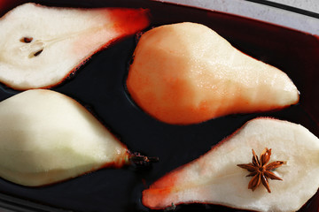 Pears with wine and spices in dish, closeup