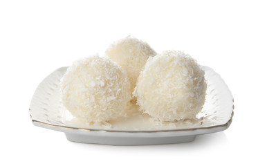 Plate with coconut candies on white background
