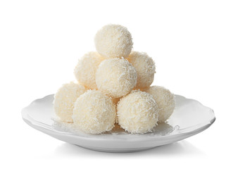 Plate with coconut candies on white background