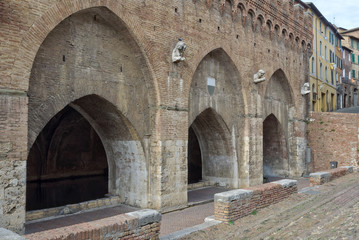 Fototapeta na wymiar The arches of the Fonte Branda in Siena, Italy