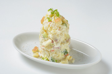 Fruit mixed with creamy potatoes on white platter