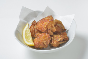 Fried pig's skin with lemon on white background