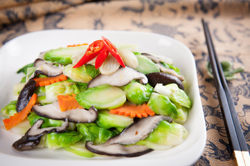 Sauteed squid with cabbage and carrot on white platter