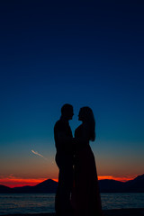 Silhouettes at sunset on the beach in Montenegro