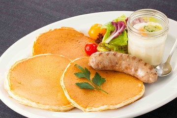 Fried sausages with  lettuce, bread and juicy fruit on white platter