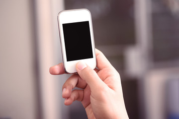 Hand holding smart phone with blank screen