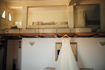 Fototapeta na wymiar The bride's dress on a hanger in the room in Montenegro