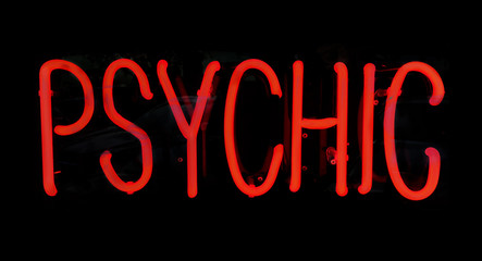 Psychic red neon light sign glowing at night.