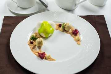 cake of ice cream on a white round plate decorated