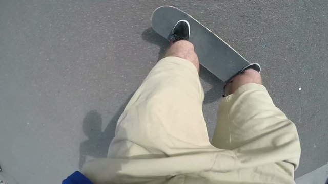 Point of view shot of skateboarder skating around a park and doing tricks and jumps
