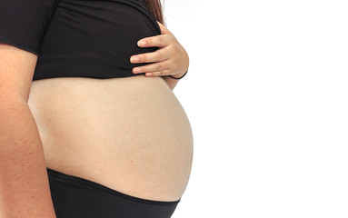 Closeup of a belly of a pregnant woman with white background. soft-focus and over light