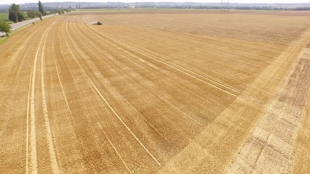 Aerial of a tractor on a acre. Grubbering the field. Europe, Germany. Near Cologne. July 