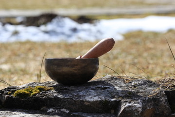 closeup of a tibetan singing bowl with its mallet 