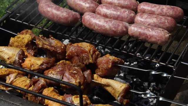 Sausages, chicken and beef getting cooked for summer barbecue, slow motion HD