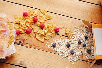Golden corn flakes, Hercules oat and some on a wooden table.