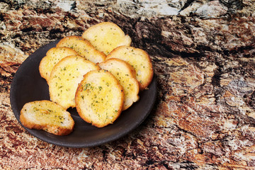 Garlic bread on black retro plate