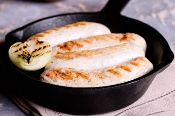 Home-made Pork Sausages in rustic pan with onion