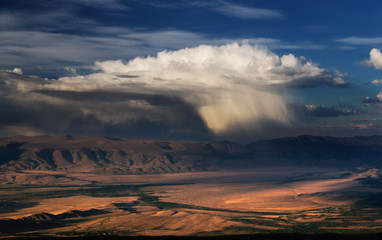 A top view to sunset highland yellow steppe plateau valley on a background of dramatic mountains...