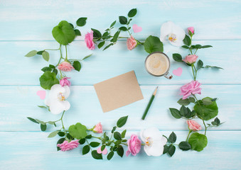 Floral frame consists of roses and orchid flowers and empty paper with coffee cup