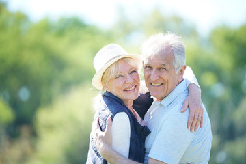 Cheerful senior couple embracing each other in countryside