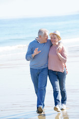 Fototapeta na wymiar Senior couple walking on the beach