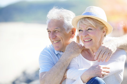 Senior couple relaxing by the sea on sunny day