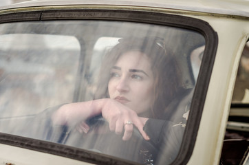 Young beautiful girl driving an old vintage car