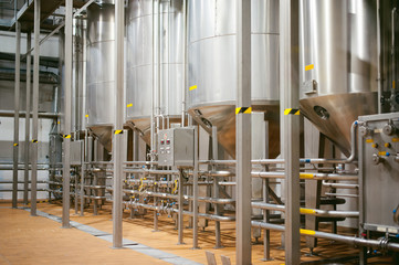 Beer manufacture line. Equipment for staged production bottling of Finished food products. Metal structures, pipes and tanks at enterprise factory. Special equipment inside within industrial premises
