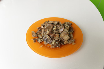 Fried mushrooms with onions and spices in an orange dish