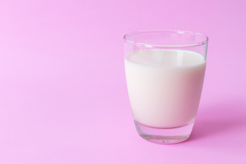 Closeup glass of milk on pink background, food and drink for healthy concept, selective and soft focus