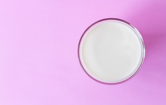 Closeup Top view glass of milk on pink background, food and drink for healthy concept, selective and soft focus