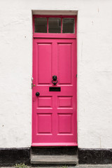 Bright pink Victorian British front door on a white empty wall