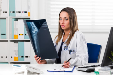 Female doctor looking at patients x-ray in her office