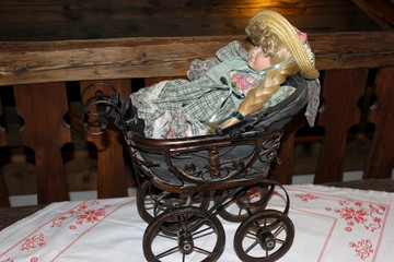 Porzellanpuppe in einem Puppenwagen