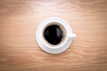 Isolated cup of espresso. Hot coffee on wooden table.