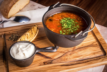 Fresh soup Solyanka with lemon and sour cream