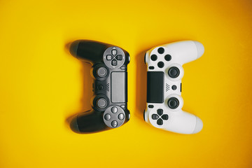 Computer gaming competition. Gaming concept. White and black joystick on yellow background. © luengo_ua