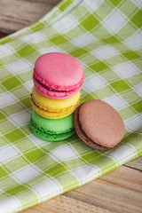 Brown, yellow, green and pink macarons on the plaid napkin