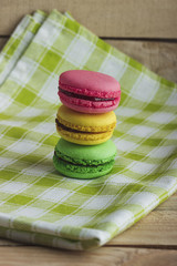 Yellow, green and pink macarons on the plaid napkin