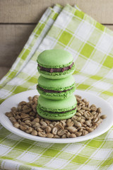 Green macarons on the plate with green coffee beans