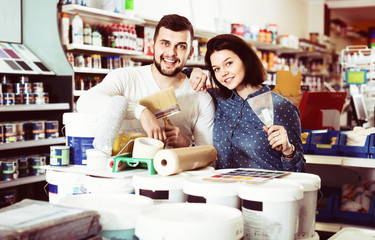 Couple purchasing tools for house improvements in paint supplies store