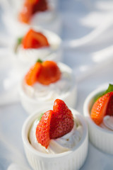 Cupcakes with whipped cream decorated with fresh strawberries